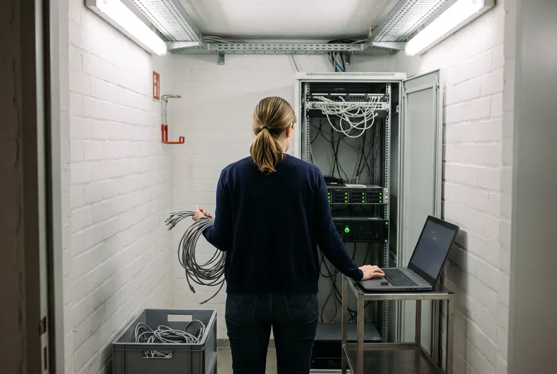 Een netwerkbeheerder in een kleine serverruimte